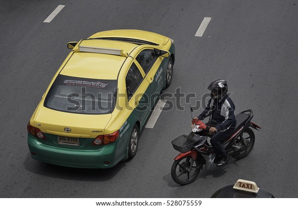 CENTER, BANGKOK, THAILAND\
- SEPTEMBER 2016: Thai meter taxi and a scooter from above on a\
Bangkok street.