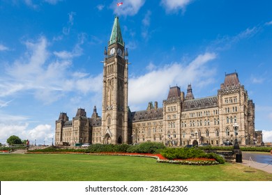 The Center Block and the Peace Tower in Parliament Hill, Ottawa, Canada. Center Block is home to the Parliament of Canada. The central green lawn and the red flowers  front the iconic building. - Powered by Shutterstock