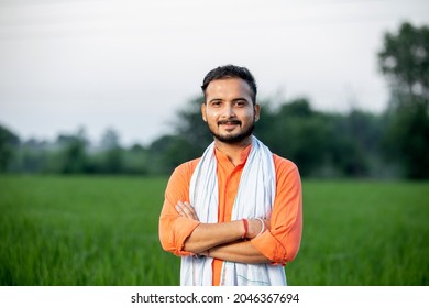 center positioned portrait of young indian farmer in farm field background rural india