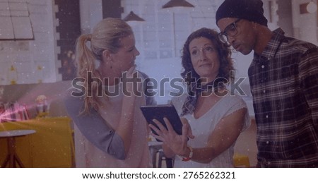 Center presenter tapping tablet, three coworkers leaning in and discussing layout in lounge. Collaboration, teamwork, office, modern, creative, warmlight, productivity