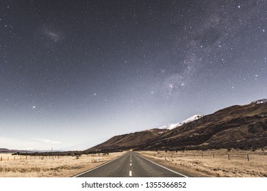 Center Of The Road In The Mt Cook National Park With The Milky Way Above The Mountains At Night Time.