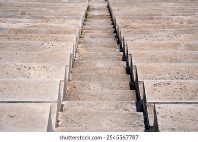 Centered steep stairway, carved of white stone, leads down the aile of tiered stadium seating in the Panathenaic Stadium of Athens, Greece. - Powered by Shutterstock