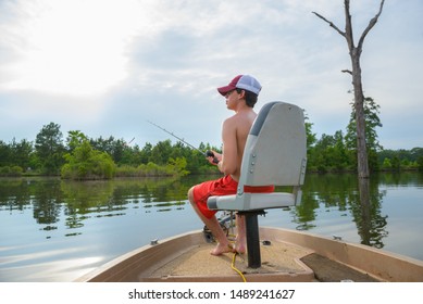 CENTERPOINT, L.A. / USA - MAY 31, 2019:  A Teenage Male Is Casting A Fishing Pole In A Bass Pond, Calm Water, Fresh Water Fishing Area Located In South Louisiana.