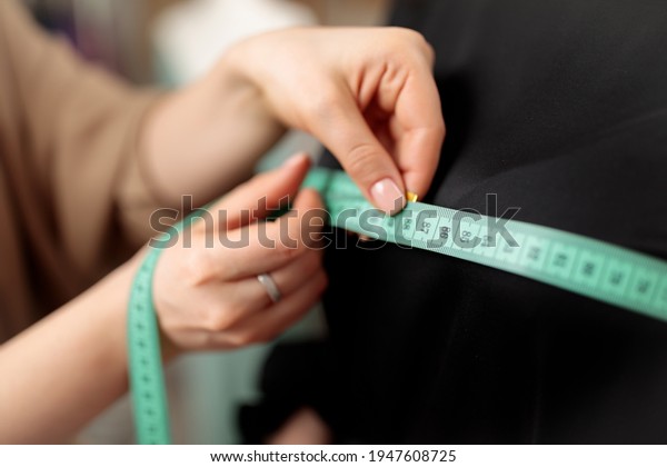 A centimeter is a tailor\'s tool for measuring when\
sewing. A centimeter is a tool for measuring dimensions. A meter\
for sewing clothes. Tailoring for the tailor. Human hands. Close\
up