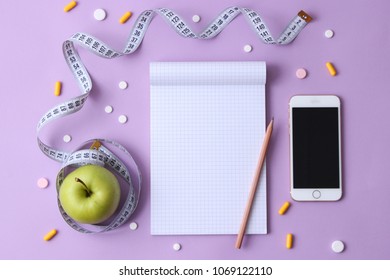 Centimeter Tape, Notebook And Tablet On A Colored Background With Space For Text. Concept Of Health, Weight Loss, Diet, Burning Of Colonies, Overweight. Minimalism, Top View.  Flatlay 