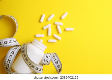 centimeter tape and pills on a colored background with space for text. concept of losing weight, diet, fat burning, healthy eating. minimalism.  - Powered by Shutterstock