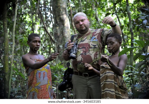CENTRAL AFRICAN REPUBLIC - NOVEMBER 2, 2008: The\
white person the tourist and women from a tribe of pygmies of Bakf\
in the forest. Dzanga-Sangha Forest Reserve, Central African\
Republic, Nov. 2, 2008