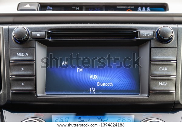 The central control console on the panel inside\
the car close-up with climate control and audio system and a hole\
for the CD and emergency button in gray and black. Auto service\
industry.