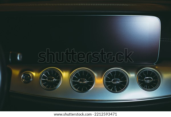 Central deflectors for heating and ventilation\
of the interior of a luxury, modern car. The interior of a modern\
car with a large touch screen, selective focus. Car ventilation\
deflector close-up.