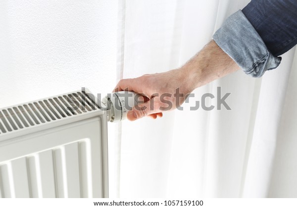 Central heating.\
The man\
adjusts the heat by turning the central heating radiator knob at\
home.\
