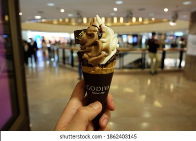 CENTRAL, HONG KONG- NOVEMBER 27, 2020: Hand Holding Waffle Cone Of 'Godiva Chocolatier' Turkish Owned Chocolate And Ice Cream Maker