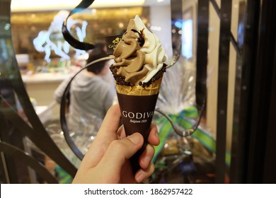 CENTRAL, HONG KONG- NOVEMBER 27, 2020: Hand Holding Waffle Cone Of 'Godiva Chocolatier' Turkish Owned Specialty Chocolate And Ice Cream Maker