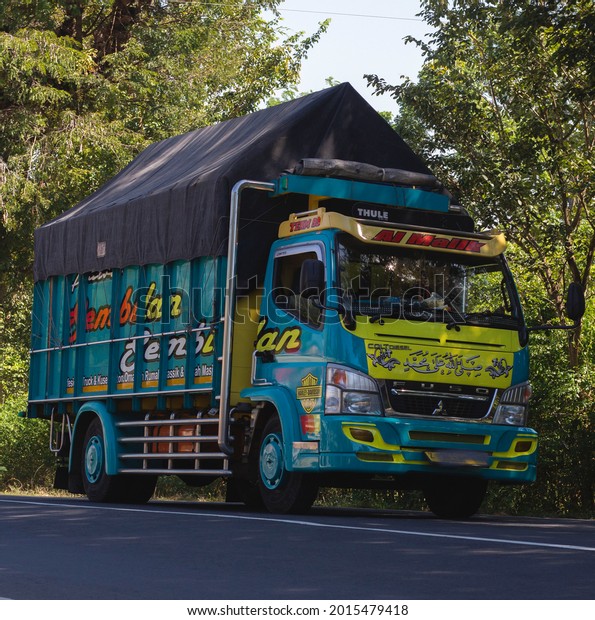 Central Java, Indonesia, July 28, 2021, truck\
with a load crossing the road. Truck modifications with attractive\
colors for the viewer.