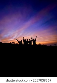 Central Java, Indonesia, May 21st 2023, Silhouette Of A Group Of People With Orange Sky In The Background Celebrating Sunrise At The Top Of Mount Merapi