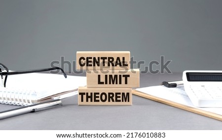 CENTRAL LIMIT THEOREM text on a wooden block with notebook,chart and calculator, grey background