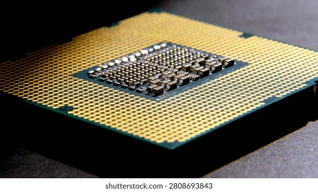 Central processing unit featuring gold pins and complex circuitry on a dark surface, highlighting modern computing technology and design intricacies