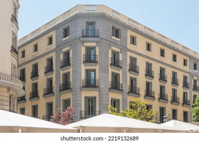 A central square of the city of Madrid with white awnings with many facades of urban residential buildings of old construction with a lot of stone and metal - Powered by Shutterstock