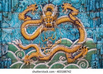 Central yellow dragon with raised forepaws, clouds and waves on the nine dragon wall in the Forbidden city in Beijing - Shutterstock ID 403188742