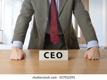 CEO leaning on desk in an office - Shutterstock ID 557952595