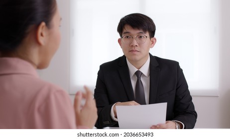 CEO Man Or HR Boss In Suit Search New Hire Vacancy Labor Ask In CV Career Paper At Office Desk. Asia SME Owner Or Lawyer People Listen Or Coach Talk To Worker Agent, Teach Intern, Advice Bank Loan.