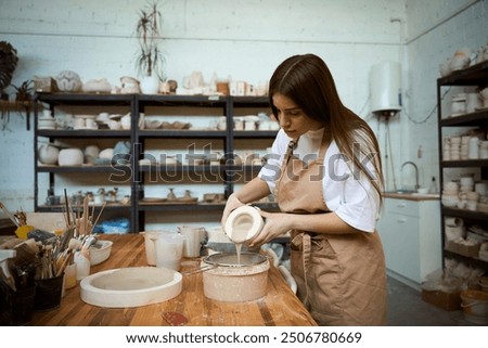 Similar – Image, Stock Photo Young female sitting by table and making clay or ceramic mug