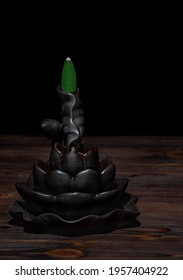 Ceramic backflow incense burner in the form of lotus flower. Incense cones holder. Dark mystic concept.