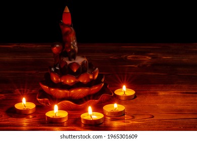 Ceramic backflow incense burner in the form of lotus flower with little candles. Incense cones holder. Dark mystic concept.