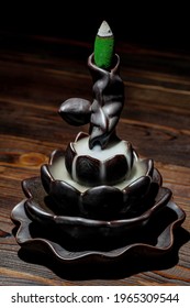Ceramic backflow incense burner in the form of lotus flower. Incense cones holder. Dark mystic concept.	