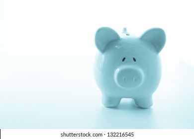 Ceramic blue piggy bank with copy space on white background