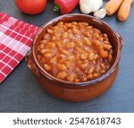 Ceramic bowl of baked beans with tomato sauce on the table 