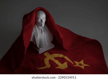 Ceramic bust of Lenin against the background of the red flag of the Soviet Union with a hammer and sickle.
