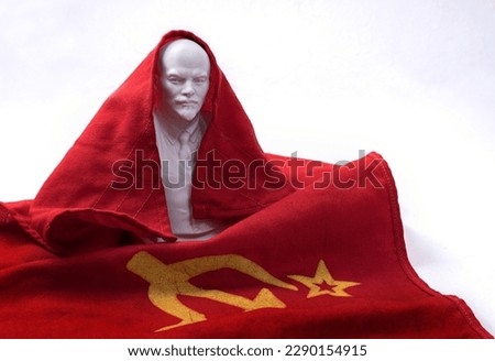 Ceramic bust of Lenin against the background of the red flag of the Soviet Union with a hammer and sickle.
