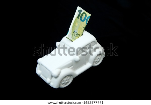 The ceramic car shaped money box with a\
banknote inside. It can be symbol for costs for car´s repairs,\
investment, savings or insurance.\
