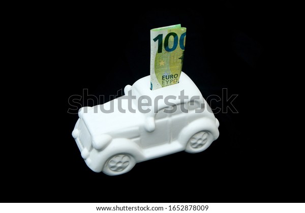 The ceramic car shaped money box with a
banknote inside. It can be symbol for costs for car´s repairs,
investment, savings or insurance.
