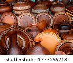 Ceramic clay brown terracotta jug, pot, plate, cup kitchen souvenirs pile at street handicraft pottery shop. Old earthen terracotta plate, jug, pot, clay jar pattern in store. Clay various ceramic pot