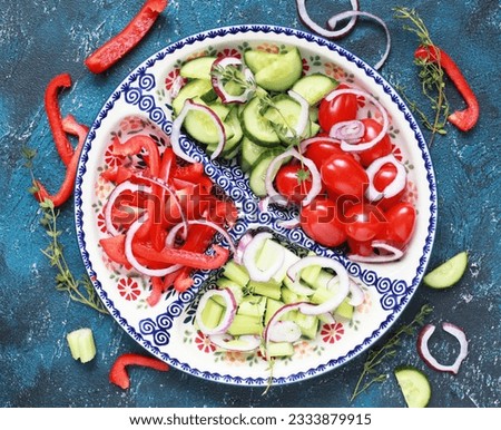 Ceramic compartmental dish with fresh chopped vegetables: cucumber, sweet pepper, cherry tomatoes and onions. Selective focus.  Stock photo © 