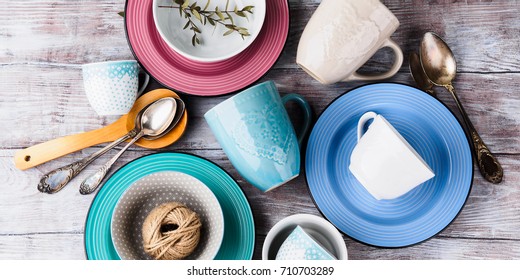 Ceramic crockery tableware on wooden background. Pastel vintage color bowls, dishes, cups