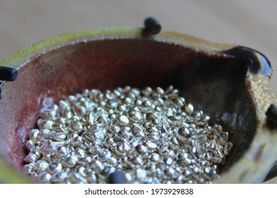 A ceramic crucible or melting pot with grains of sterling silver 925 for jewelry making after hand smelting in a workshop. One of the two major precious metals on the market.