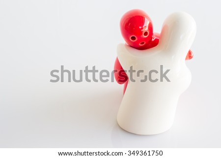 Ceramic doll with red and white on white background with copy space.