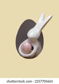 The ceramic Easter Bunny holding the pink Easter Egg is peeking out of the paper hole.
