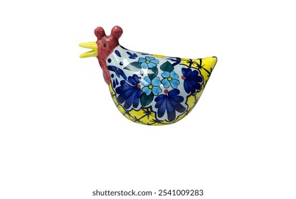 A ceramic figurine of a chicken. The chicken is yellow with blue and white floral patterns. It has a red comb and beak. - Powered by Shutterstock