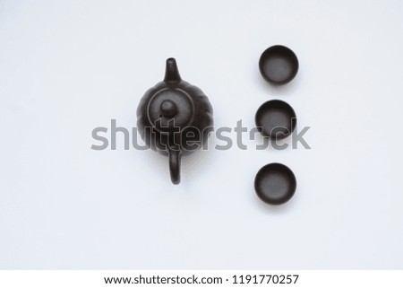A ceramic kettle with three cups, close view, white background