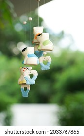 Ceramic mobile hanging from the ceiling with blurred landscape background. Modern chimes in the garden