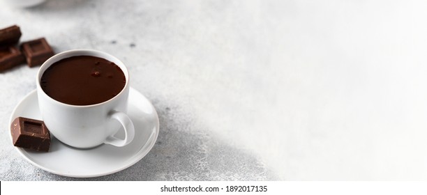 Ceramic mug with hot chocolate and chocolate slices on concrete background. Large image for web banner.