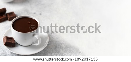 Ceramic mug with hot chocolate and chocolate slices on concrete background. Large image for web banner.