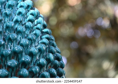 Ceramic pine cone in a park against a blurred background - Shutterstock ID 2254459147