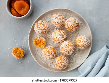 ceramic plate with vegan energy balls with dried apricots and coconut. vegan food concept. Gray background. top view