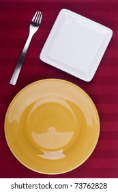 Ceramic plates for table on a red background.