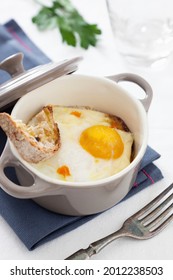 Ceramic pot with single portion baked egg on toasted bread