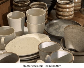 Ceramic tableware displayed on rustic surface under soft daylight, ideal for kitchen backgrounds. Mobile photo